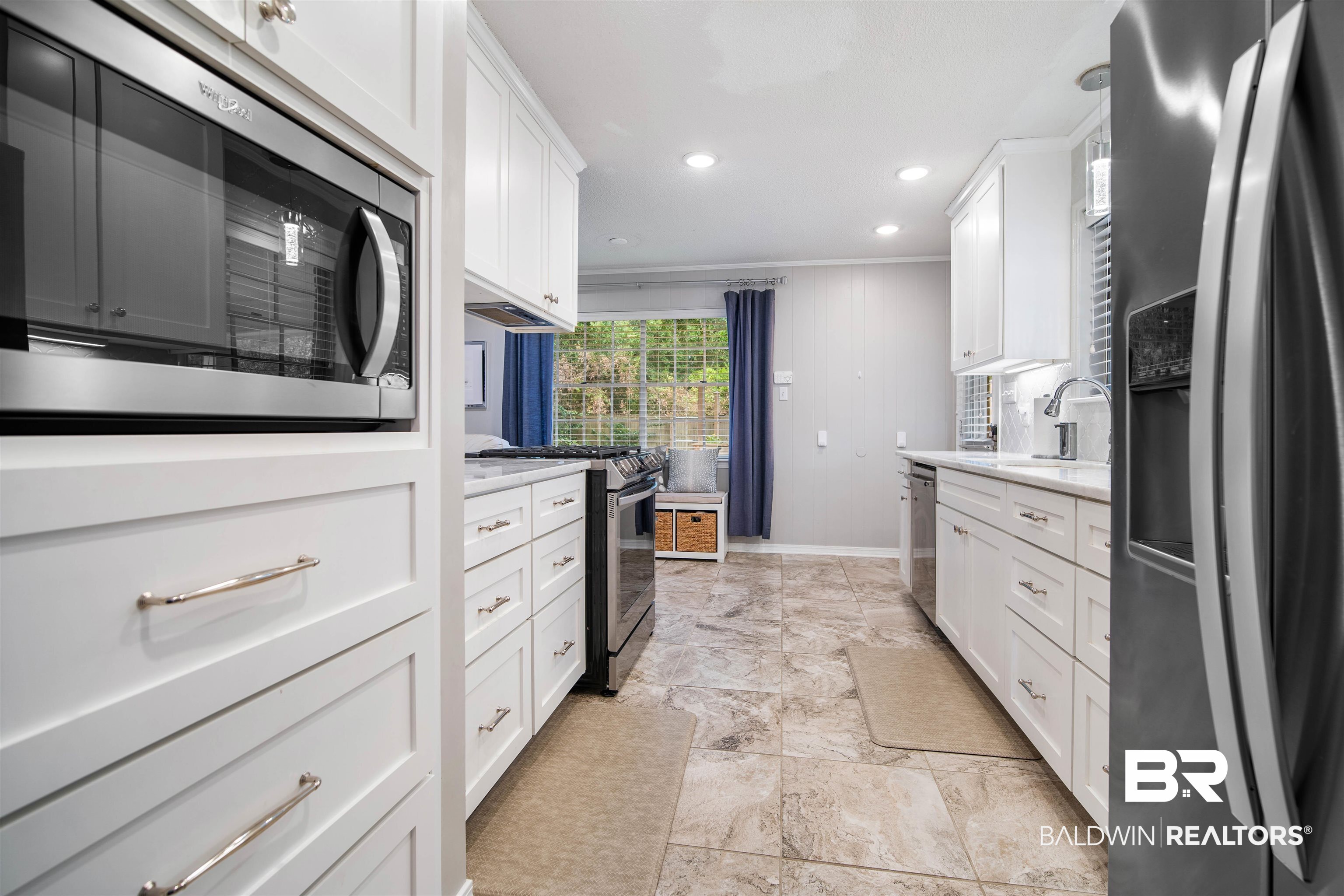 4228 Spring Valley Drive South Mobile, AL 36693 - Photo 7 of 31 Kitchen with appliances with stainless steel finishes, ornamental molding, sink, white cabinetry, and hanging light fixtures
