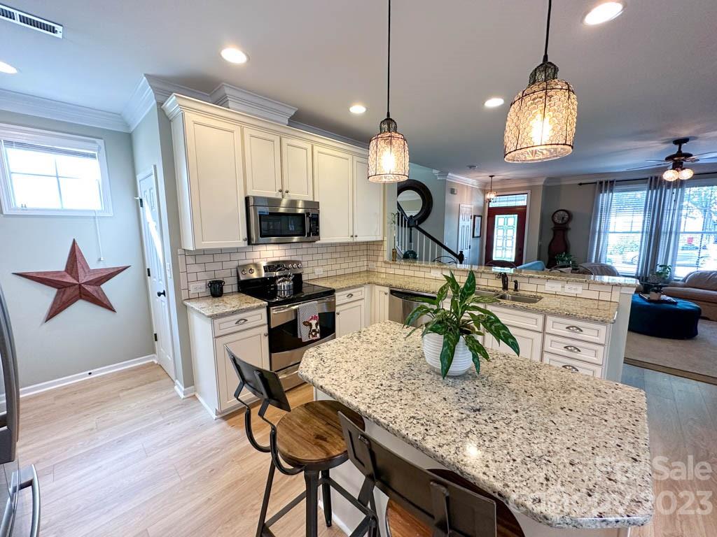 3470 Richard's Crossing Fort Mill, SC 29708 - Photo 8 of 29 a kitchen with granite countertop a stove a sink dishwasher a dining table and chair with wooden floor