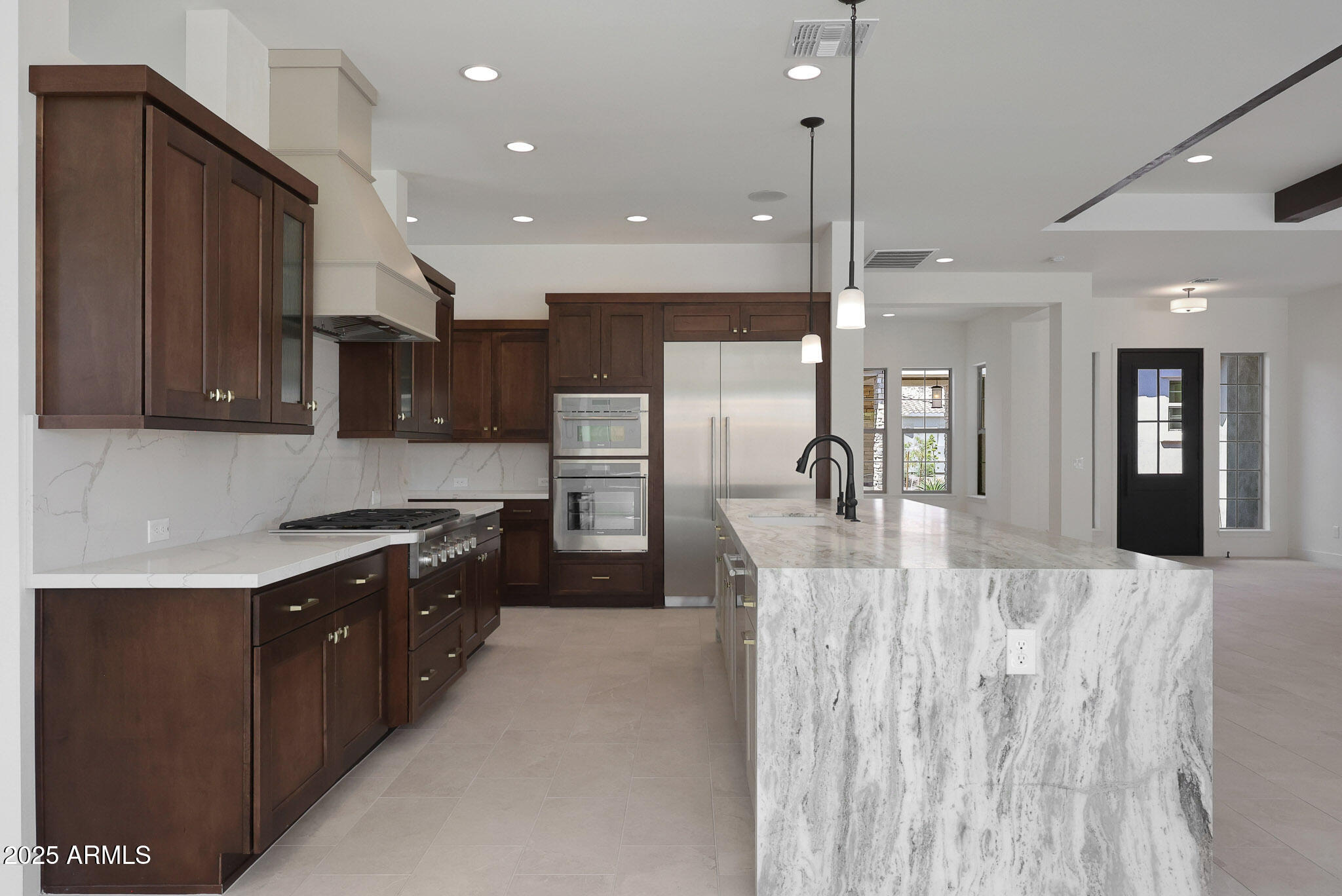 20775 West Rattler Road Buckeye, AZ 85396 - Photo 17 of 90 a large kitchen with stainless steel appliances kitchen island granite countertop a refrigerator and a stove top oven