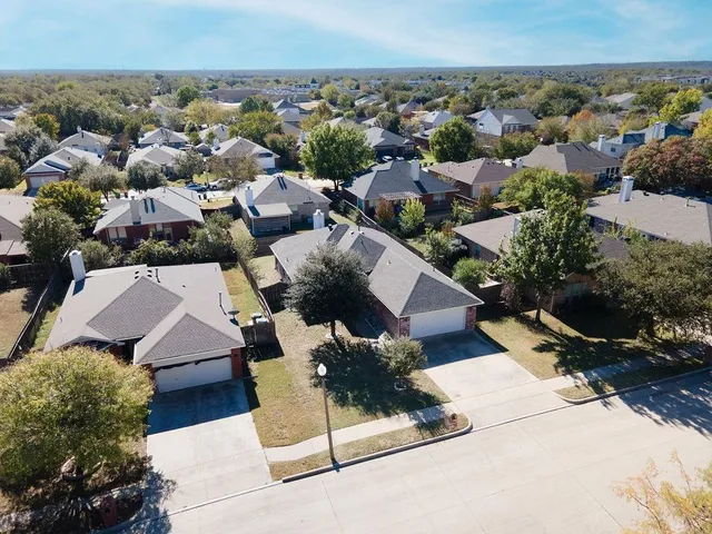 an aerial view of multiple houses with a yard