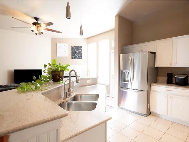 a kitchen with stainless steel appliances granite countertop a stove a sink and a refrigerator