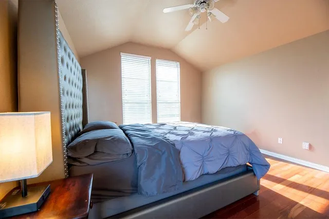 a bedroom with a bed and wooden floor
