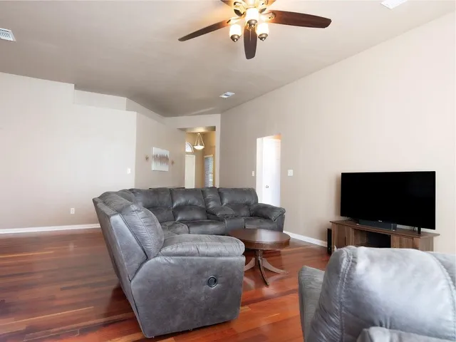 a living room with lots of wooden furniture and a large window