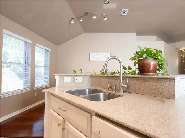 a kitchen with stainless steel appliances kitchen island granite countertop a refrigerator a stove and a sink