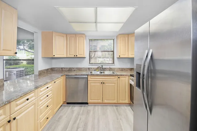a kitchen with granite countertop white cabinets and a sink
