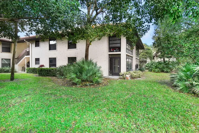 a white house that has a tree in front of it