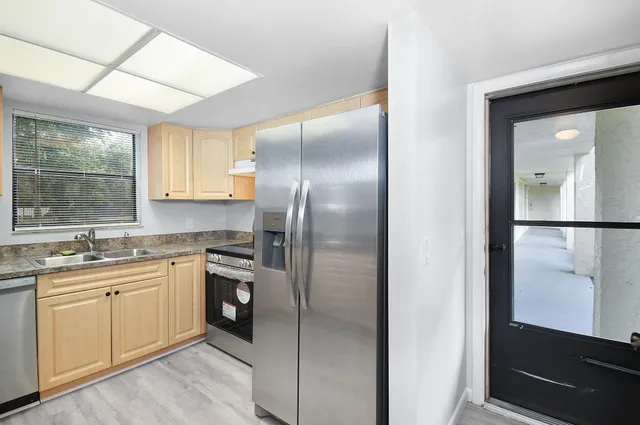a kitchen with cabinets appliances and a window