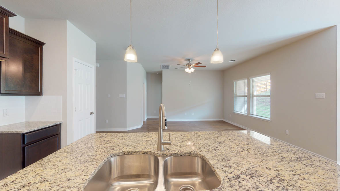 429 Creekfall Road Burnet, TX 78611 - Photo 4 of 28 A generous island with a double sink and ample counter space anchors this inviting kitchen, flowing into an open living area.