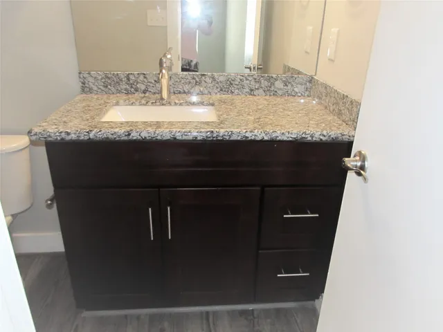 a bathroom with a granite countertop sink and a mirror