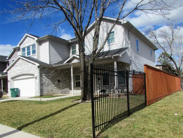 a view of a house with a yard and wooden fence