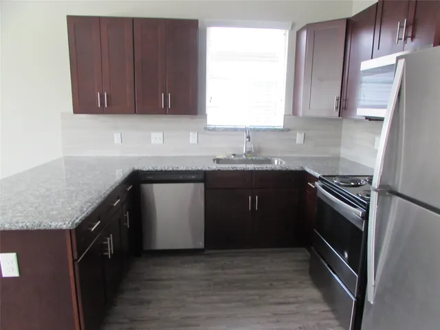 a kitchen with a sink stove top oven and cabinets