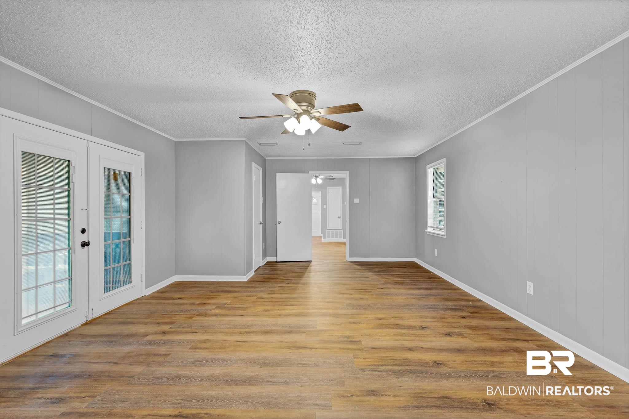 3304 Armond Drive Mobile, AL 36605 - Photo 22 of 62 Empty room with french doors, a textured ceiling, ceiling fan, crown molding, and wood finished floors
