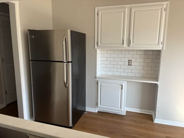 a view of a kitchen with refrigerator and wooden floor