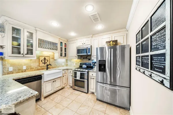 a kitchen with stainless steel appliances granite countertop a refrigerator a stove and a sink