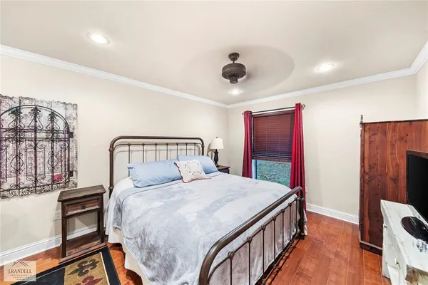 a bedroom with a bed and a flat tv screen on dresser