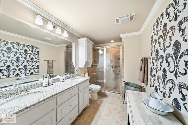 a spacious bathroom with a double vanity sink toilet mirror and shower