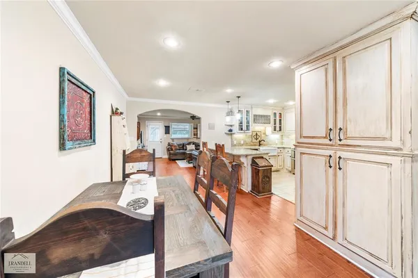 a kitchen with stainless steel appliances granite countertop a refrigerator oven a sink dishwasher and white cabinets with wooden floor