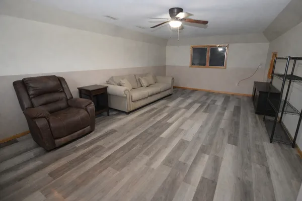 a living room with furniture and a ceiling fan