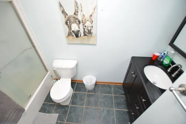 a bathroom with a toilet sink vanity and mirror