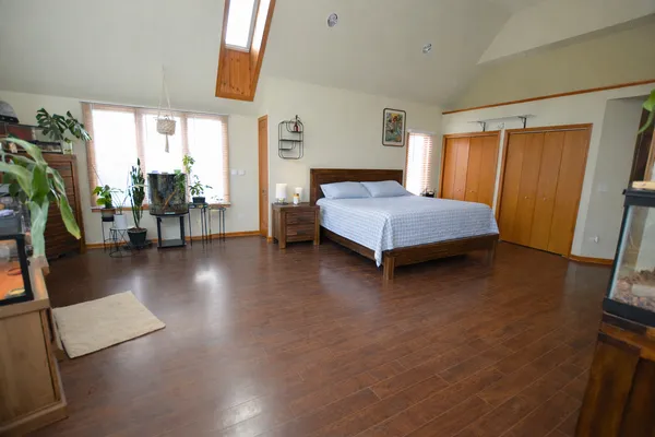 a bedroom with wooden floor and a bed