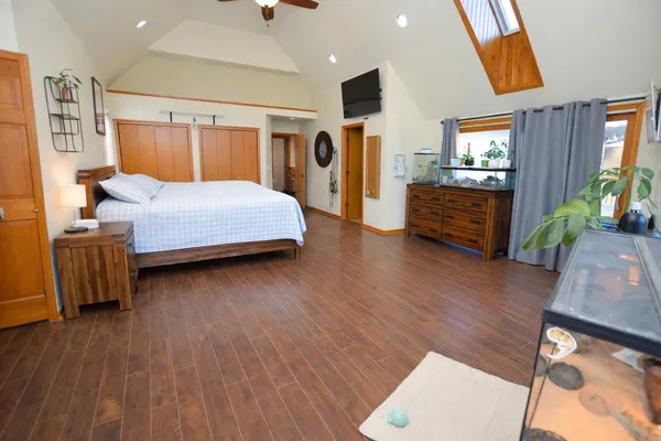 a bedroom with wooden floors and a bed