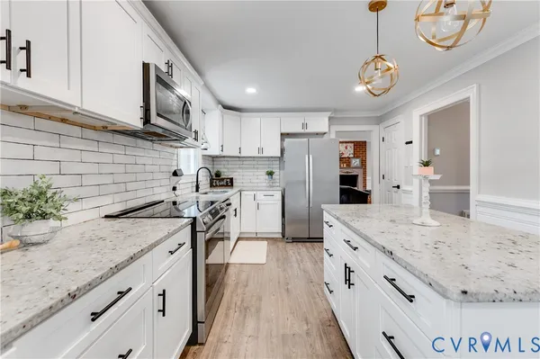 a kitchen with stainless steel appliances granite countertop a sink refrigerator stove and microwave