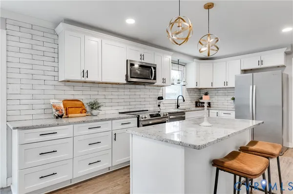 a kitchen with stainless steel appliances granite countertop a stove a sink dishwasher a refrigerator with a microwave oven and cabinets