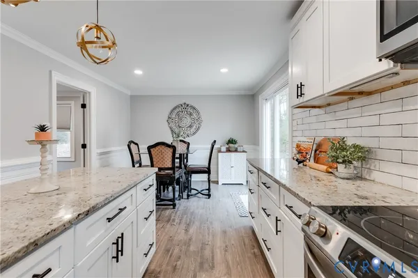 a kitchen with stainless steel appliances granite countertop a stove and cabinets