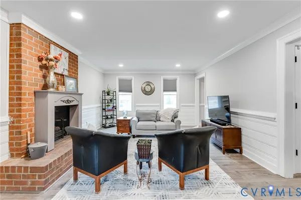 a living room with fireplace furniture and a rug