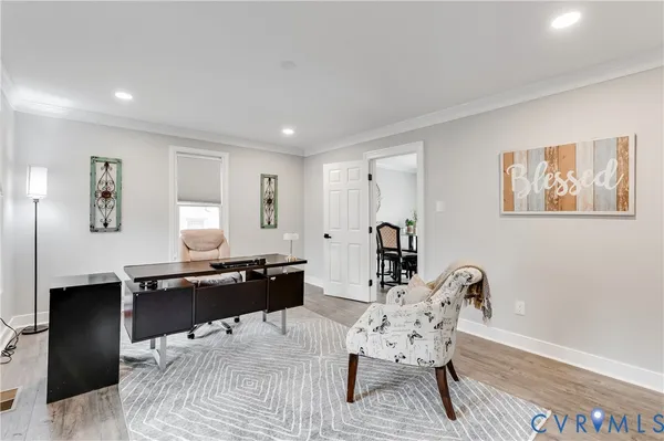 a living room with furniture a desk and chair with potted plants