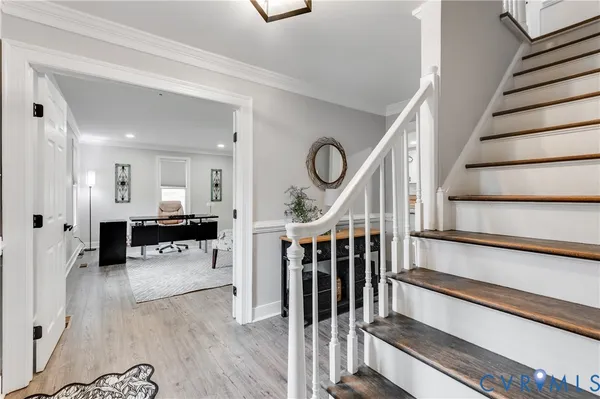 a view of a hallway with wooden floor and furniture