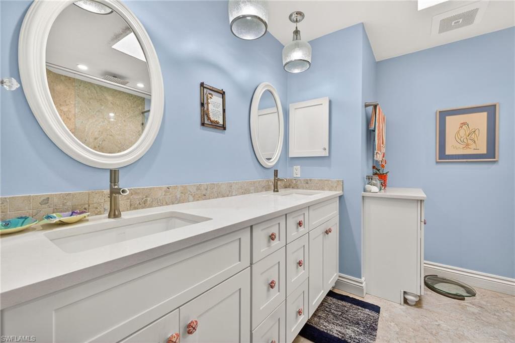 4030 Crayton Road, Unit C2 Naples, FL 34103 - Photo 24 of 32 a bathroom with a double vanity sink and a mirror