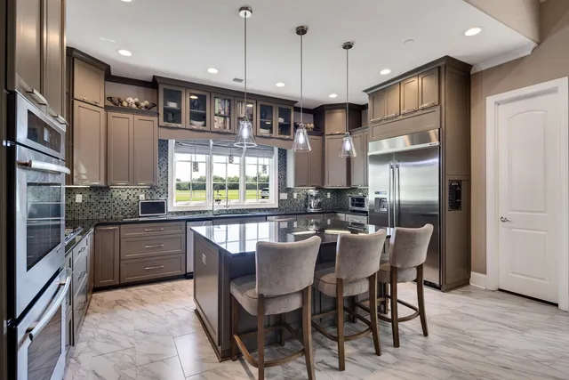 a kitchen with stainless steel appliances granite countertop a kitchen island hardwood floor and a sink