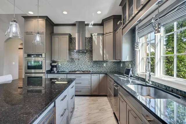a kitchen with stainless steel appliances granite countertop a sink a stove and a refrigerator