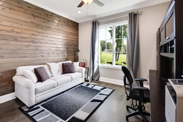 a living room with furniture gym equipment and a large window