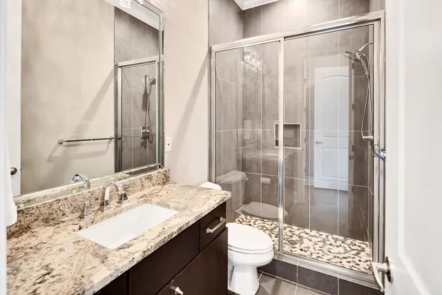 a bathroom with a granite countertop sink toilet and shower