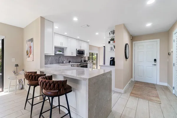 a kitchen with white cabinets and stainless steel appliances