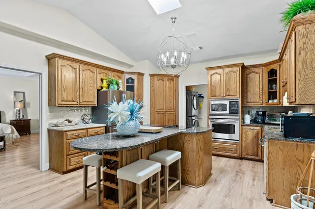 a view of a dining room with furniture a chandelier and wooden floor