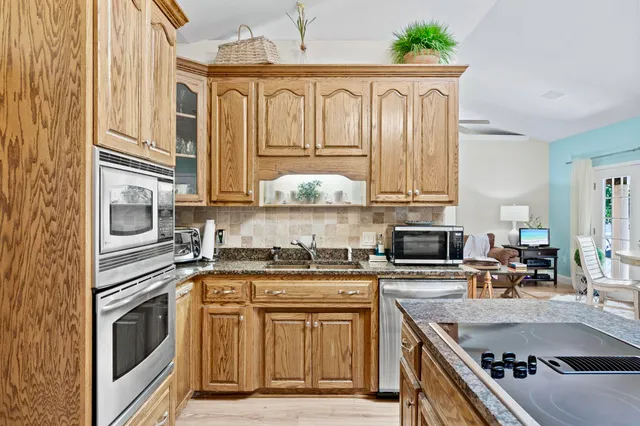 a kitchen with stainless steel appliances granite countertop a stove a sink and a microwave