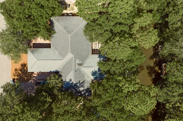 an aerial view of a house with a yard and large tree
