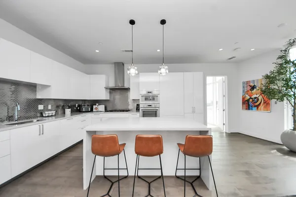 a kitchen with stainless steel appliances kitchen island granite countertop a table and chairs in it