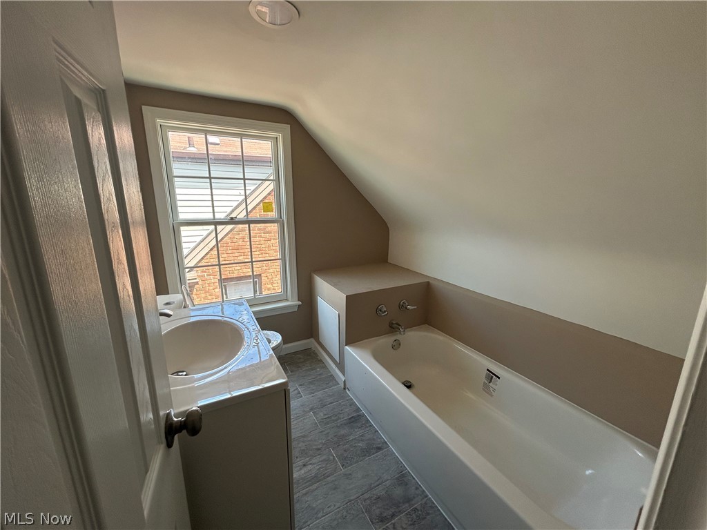 13537 Cedar Road Cleveland, OH 44118 - Photo 22 of 30 Bathroom with a washtub, vanity, tile flooring, and lofted ceiling