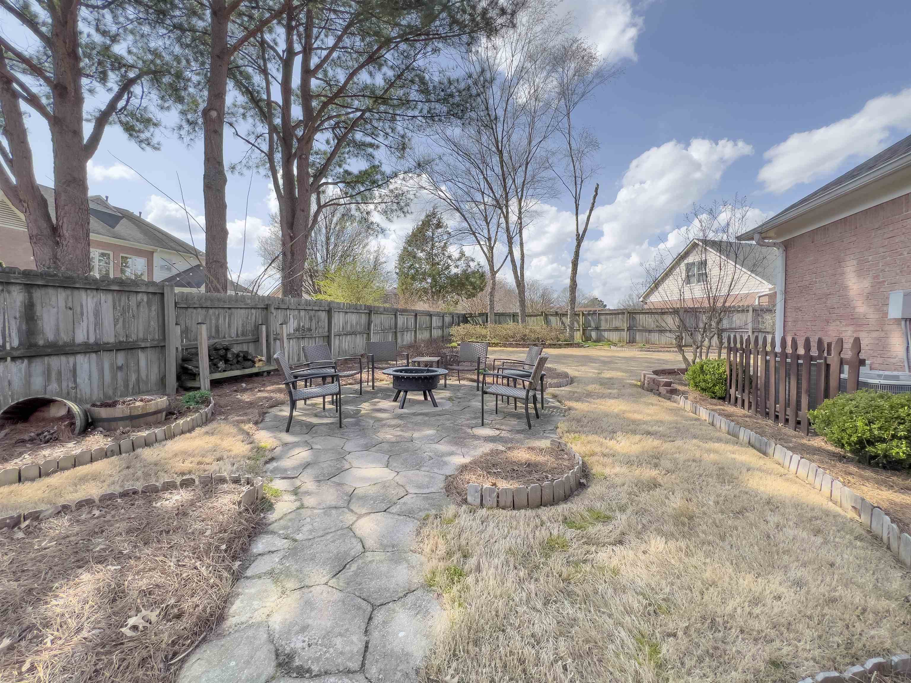 747 Steeple Ridge Cove Collierville, TN 38017 - Photo 34 of 39 a view of backyard with table and chairs and wooden fence