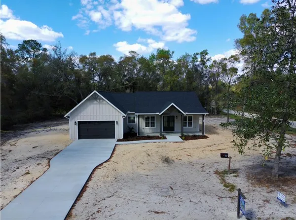 a view of a house with a yard covered in snow
