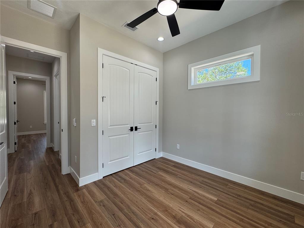 5151 Northwest 73rd Street Chiefland, FL 32626 - Photo 50 of 58 a view of a hallway with wooden floor and a ceiling fan