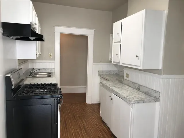 a kitchen with granite countertop a sink and a stove