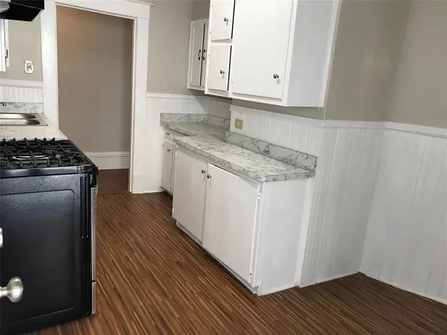 a kitchen with granite countertop cabinets stainless steel appliances and wooden floor