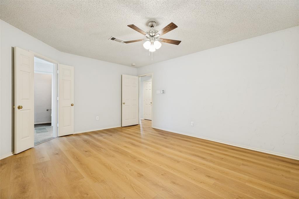 1215 Spring Creek Drive Allen, TX 75002 - Photo 16 of 40 Wood-finish flooring throughout a spacious room with light gray walls