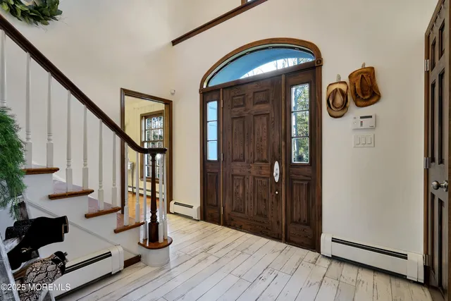 a view of entryway and hall with wooden floor and stairs