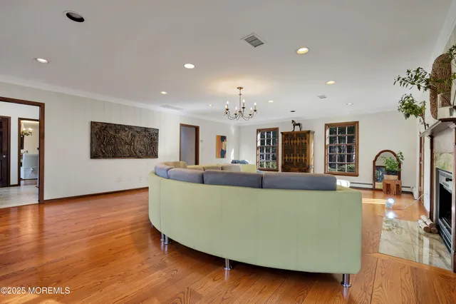 a living room with furniture a fireplace and a chandelier